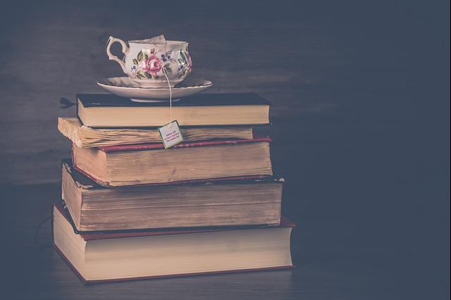 tea steeping in fancy mug on saucer on books